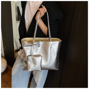 Detail of silver metallic tote bag with crinkled leather texture and mini pouch