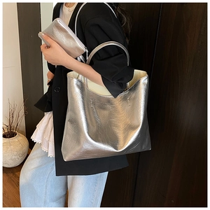 Detail view of silver metallic textured leather tote bag with matching inner zipper pouch