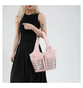 Pink patent leather punk tote bag with silver metal studs shown worn by a model