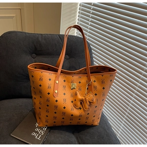 Detail of classic printed brown tote bag with bear patterns and cute puppy charm on chair