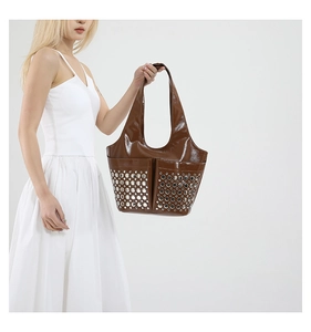 Detail of punk tote bag with silver rivets on glossy brown synthetic leather finish