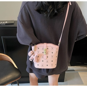Detailed view of pink crossbody bucket bag with cartoon bear prints and gold clasp