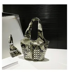 Detail of camouflage tote bag showing metallic round silver studs on durable canvas