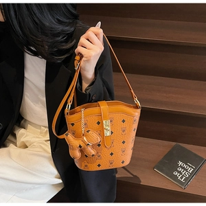 Detail of caramel brown bucket bag with vintage teddy bear print and metal clasp