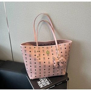 Close-up of pink textured tote bag with diamond pattern and cute puppy charm detail