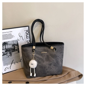 Detailed view of the dark grey vintage tote bag featuring a plush charm and soft faux leather