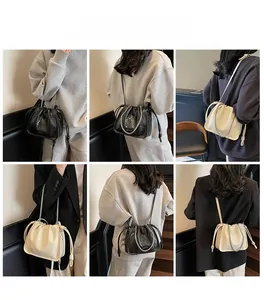 Detail showing woven texture bucket bag in black and off-white with chain strap styles