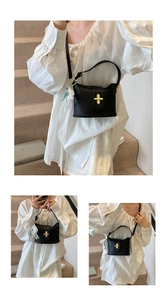 Detail view of black lychee grain bucket bag with gold cross lock and lace pearl charm