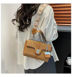 Details der camelfarbenen Webleder-Handtasche mit besticktem Gurt und Metall-Drehverschluss
