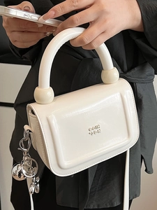 Sac à main blanc élégant en cuir brillant avec poignées rondes et détails sphériques