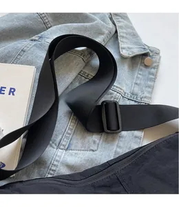 Detail of adjustable black nylon shoulder strap on denim jacket for casual crossbody bag