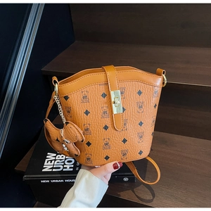 Detailed view of a brown monogram bucket bag with teddy bear print and gold buckle clasp