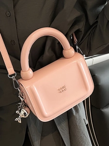 Petit sac bandoulière rose en cuir verni avec poignée ronde et pendentif argenté
