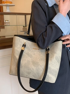 Minimalist large capacity tote bag with marble pattern and black leather straps shown on model