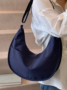 Minimalist navy blue nylon crescent crossbody bag with double front pockets and shoulder strap