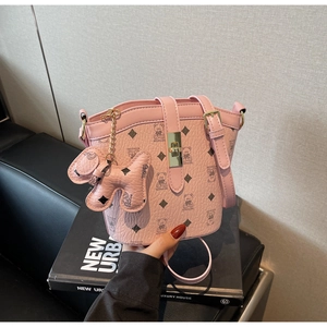 Detail of pink bucket bag with cartoon bear pattern and gold metal clasp closure