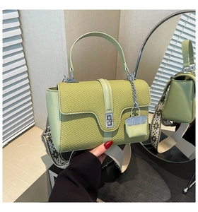 Detail der avocadogrünen Tasche mit breitem Ethno-Gurt und Metall-Drehverschluss