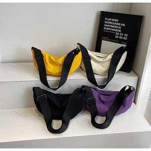 Detailed view of lightweight nylon dumpling bags in four vibrant colors on a marble display