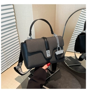 Detailansicht der grauen Web-Handtasche mit schwarzem Lederbesatz und Silber-Drehverschluss