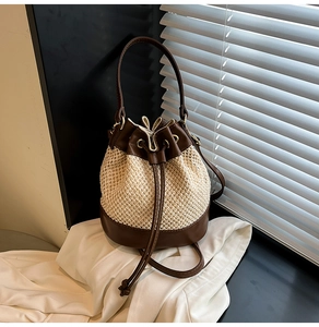 Close-up of contrast straw bucket bag with leather drawstring and textured woven detail