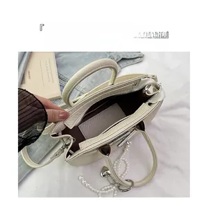Detailed interior of cream bucket bag with lychee texture and pearl heart charm
