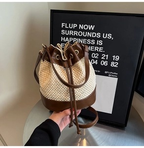 Close-up of contrast straw bucket bag featuring leather drawstring and metal eyelets