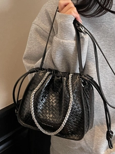 Fashionable black woven drawstring bucket bag with silver chain and thin leather straps