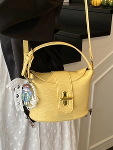 Yellow lychee textured leather bucket bag with cute charm and pearl lace detail