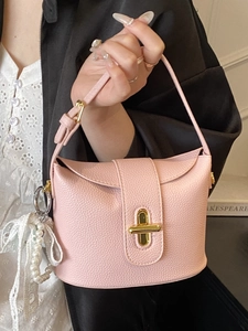 Pink lychee grain leather bucket bag with gold clasp and pearl lace pendant