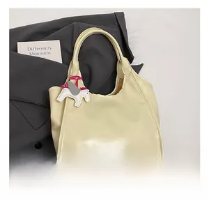 Detail view of large beige tote bag with soft wax leather texture and pony charm
