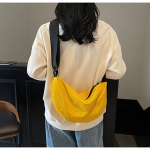 Detail showing back view of light yellow nylon crescent bag on model with black strap