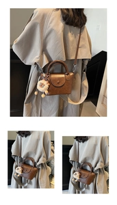 Close-up of retro dark brown leather bucket bag with cute plush lion charm and flap closure