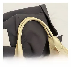 Detail view of the soft round handle and neat stitching on this cream oil wax tote bag