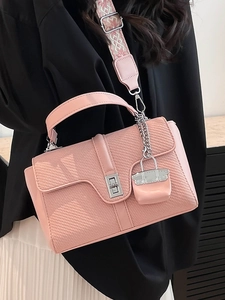 Rosa Handtasche mit Webstruktur und breitem geometrischem Gurt an einem Model
