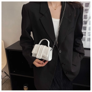 Mini sac à main blanc motif crocodile avec chaîne argentée porté avec une tenue chic