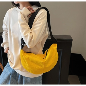Detail of a bright yellow nylon hobo bag showing adjustable black strap and fabric texture