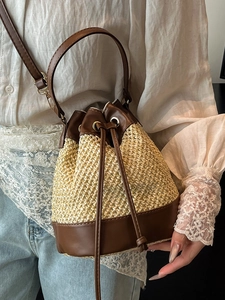 Fashionable straw and leather patchwork bucket bag with drawstring closure for women