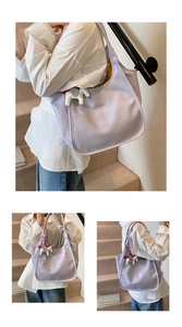 Detailed view of light purple crescent shoulder bag with horse charm on indoor stairs