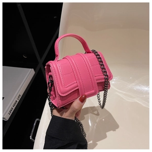 Détail du mini sac à main rose vif gaufré crocodile avec chaîne en métal et poignée