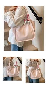Detailed view of pink oil-wax leather tote bag featuring a white horse pendant charm