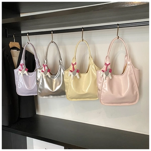Detail view of large underarm bags in purple, silver, beige and pink with pony charms