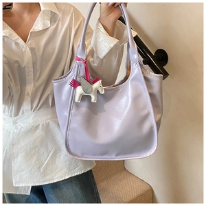 Detail view of a lavender tote bag with a small decorative horse charm for commuting