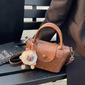 Sac à main vintage marron sur un banc avec charme lion en peluche et fond de style de vie