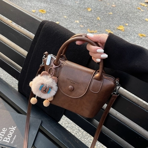 Vue détaillée du sac cabas marron vintage avec un ours en peluche sur un banc de parc