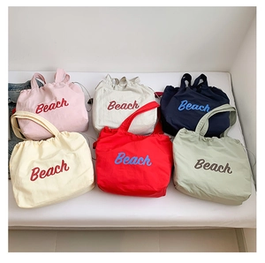 Collection of colorful canvas beach tote bags featuring Beach lettering and drawstring closure