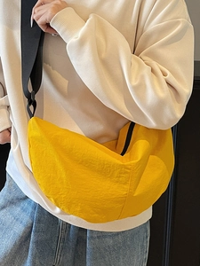 Fashionable bright yellow pleated crescent crossbody bag with adjustable wide black strap