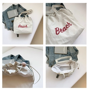 Detail view of large white canvas tote bag with Beach print and pink drawstring closure