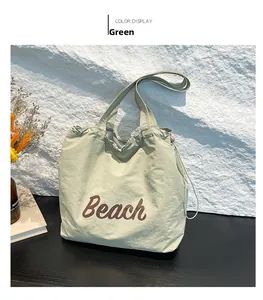 Detail of green tote bag with Beach print and drawstring feature on a minimalist set