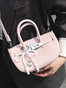 Pink lychee grain leather bucket bag with pearl bow and metal twist lock detail