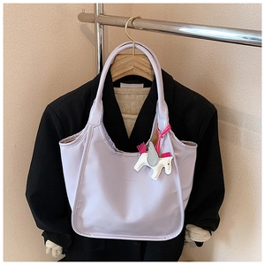 Close-up of lavender oil wax tote bag with brand logo and cute unicorn charm detail